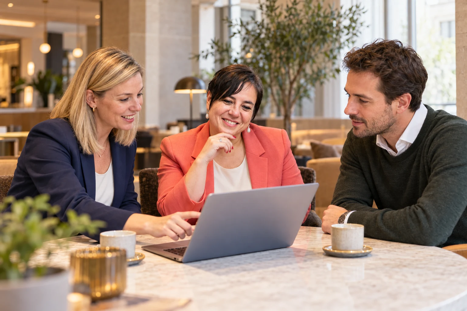 An Vermeulen overlegt met twee ondernemers bij een laptop.