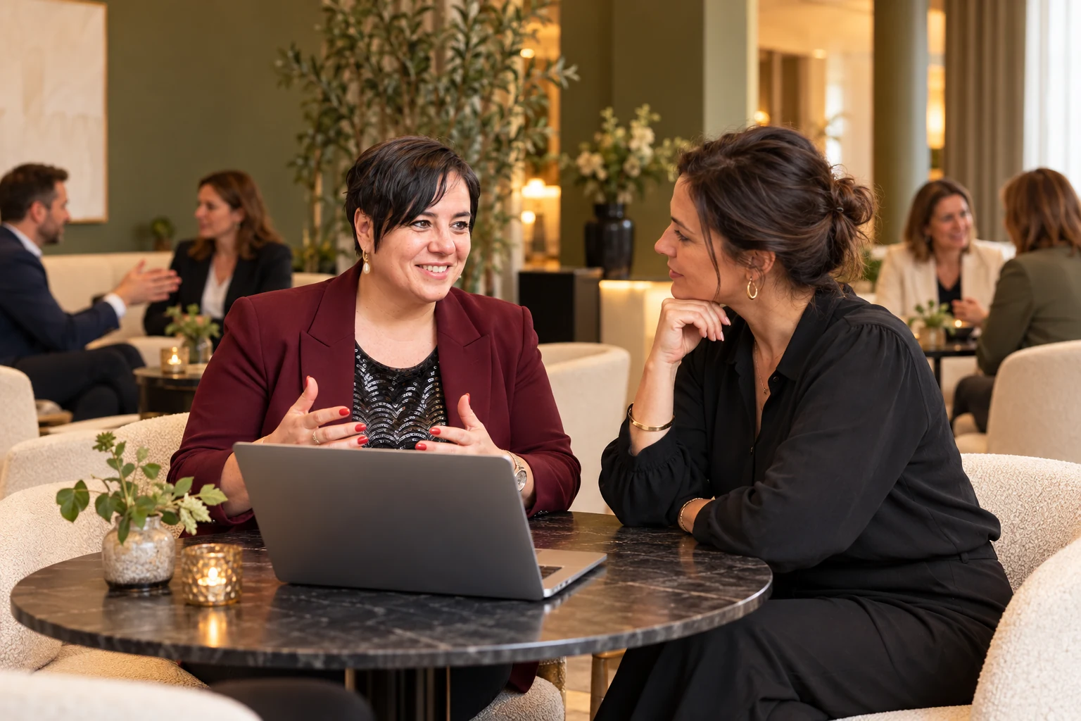 An Vermeulen bespreekt een zakelijke keuze met een onderneemster aan een laptop.