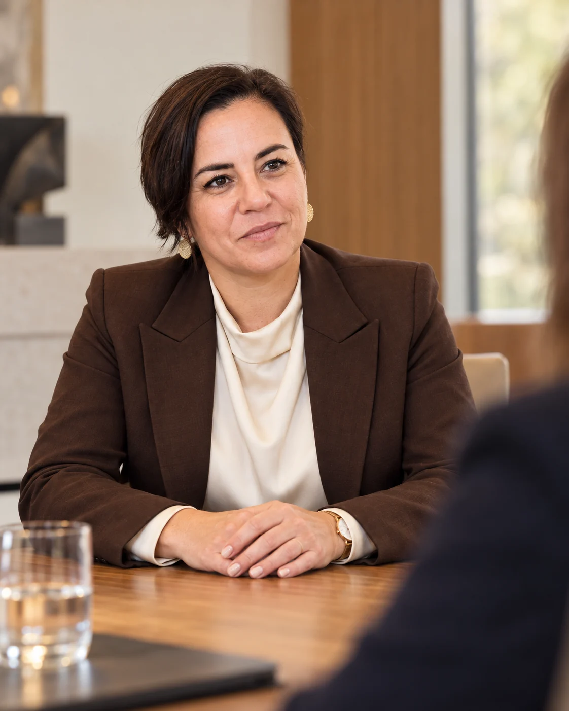 An Vermeulen in een chocoladebruine blazer en ivoorkleurige blouse.