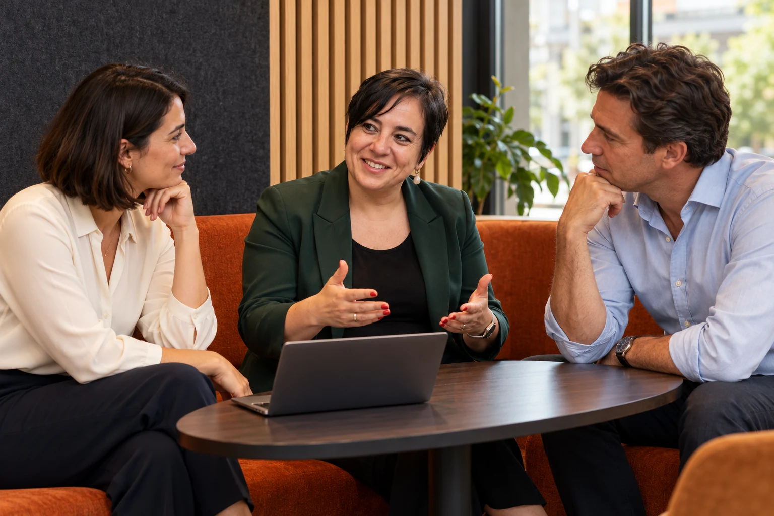 An Vermeulen begeleidt een groepsgesprek met twee ondernemers bij een laptop.